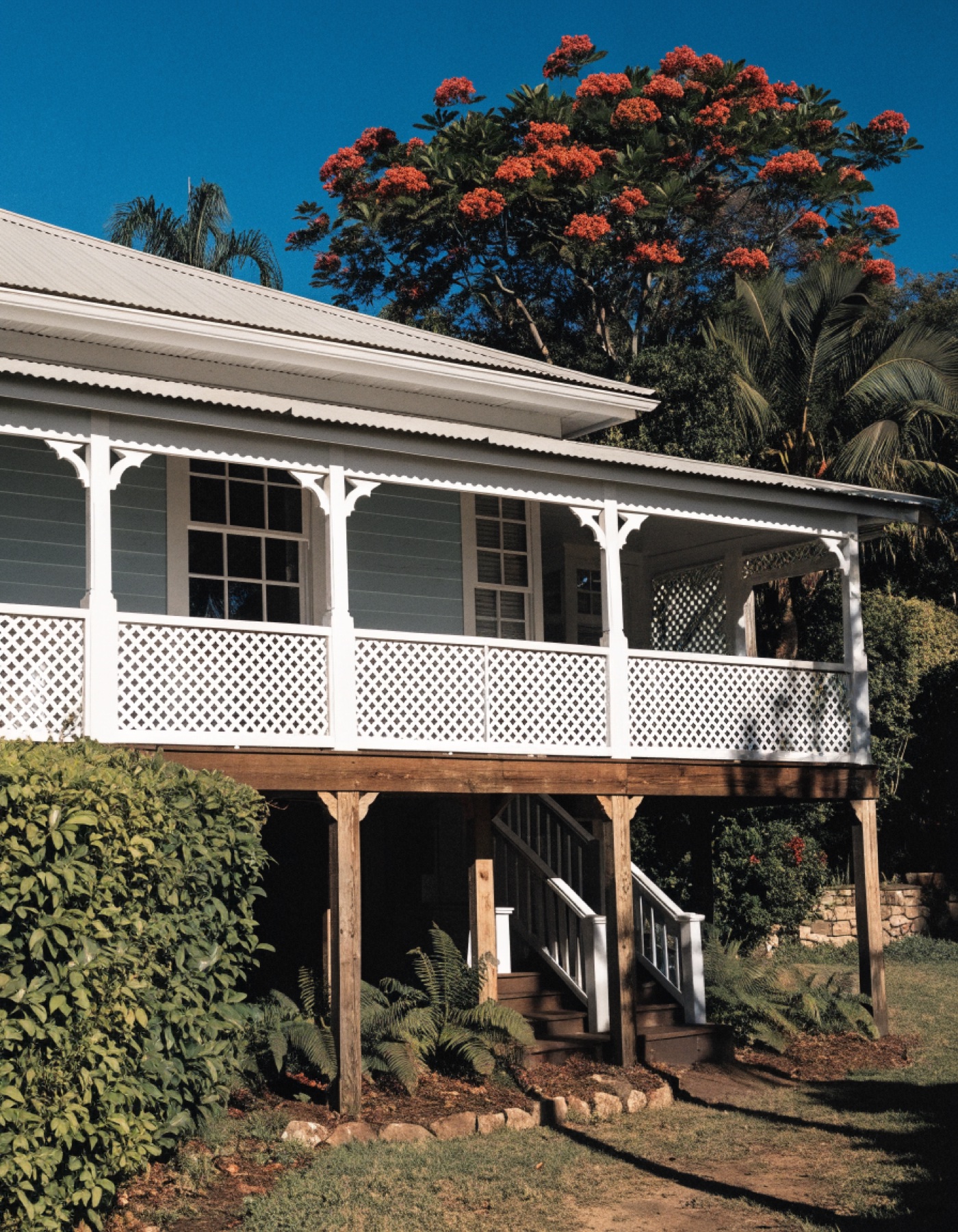 A Brisbane Queenslander home on a quiet bayside street in late afternoon light
